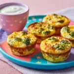 Broccoli cheddar egg muffins on colorful kids plate with yogurt