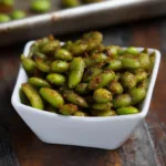 3 Vegan High Protein Snacks That Build Muscle Fast and Clean 25 Close-up of crispy roasted edamame in a white bowl, vegan protein snack