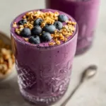 Blueberry muffin smoothie in mason jar with oats, bananas, and fresh blueberries