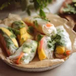 5-Minute Vegetarian Rice Paper Rolls with Vermicelli Noodles 11 vegetarian rice paper rolls with vermicelli noodles, mango, avocado, and cilantro on a ceramic plate