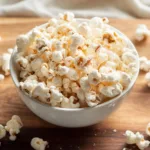Bowl of protein popcorn with vanilla dust on wooden board