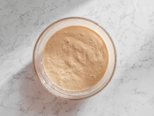 Bowl of smooth flourless banana bread batter on marble countertop