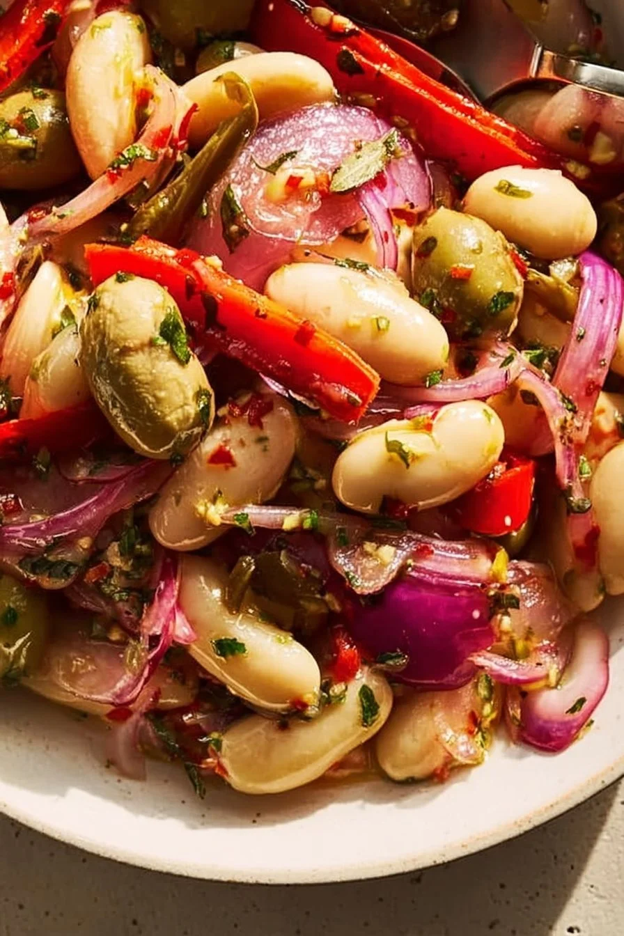 Plate of marinated butter beans garnished with herbs and spices.