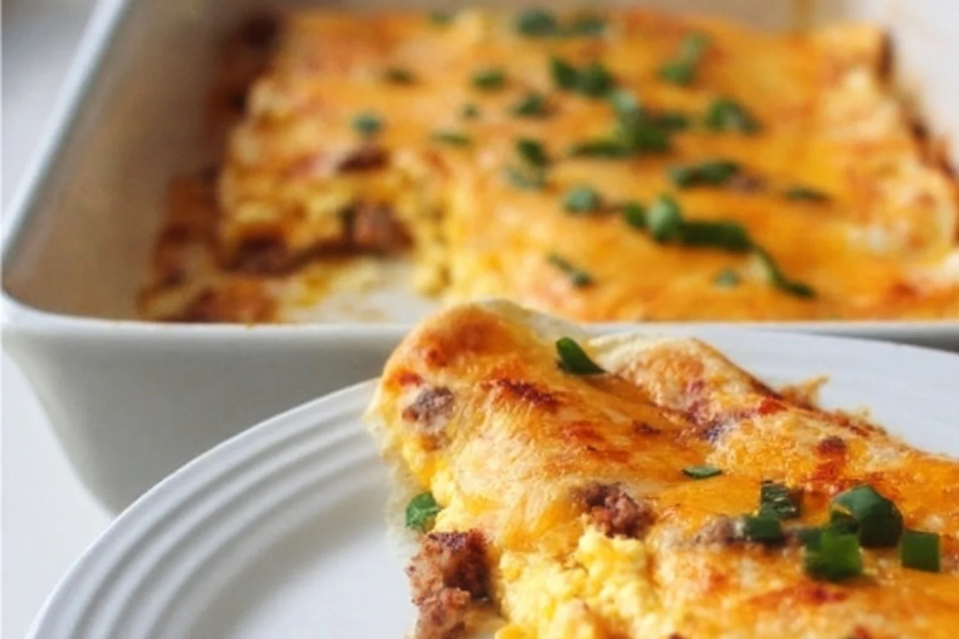 Delicious breakfast enchiladas topped with cheese and served on a plate