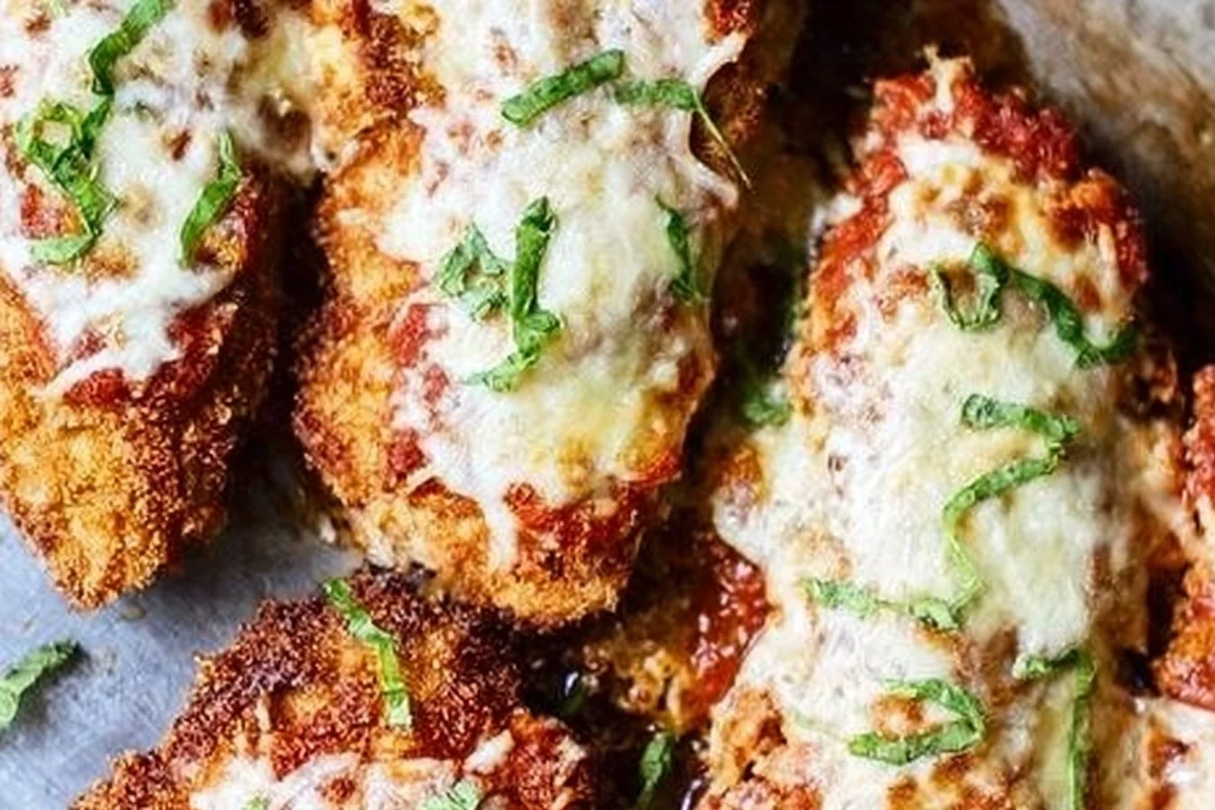 Crispy Chicken Parmesan topped with marinara sauce and cheese on a plate