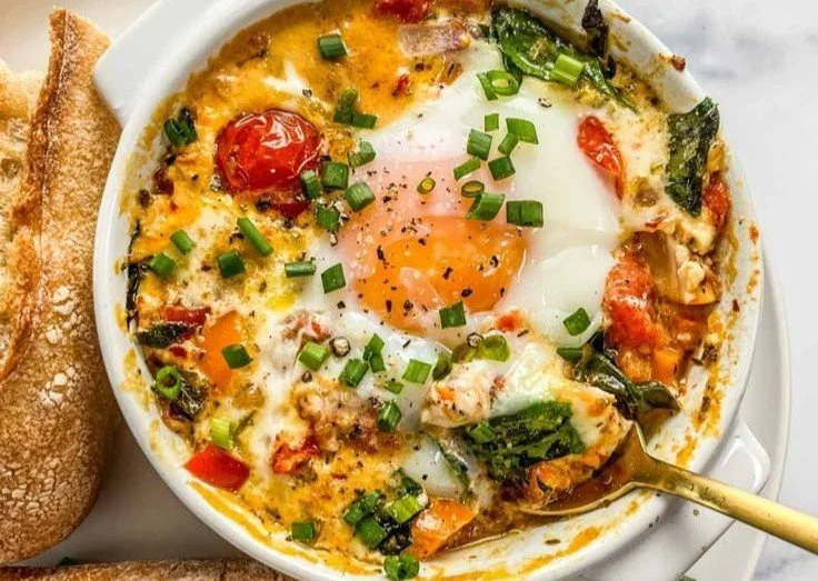Delicious baked feta eggs with spinach and tomatoes