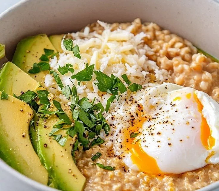Bowl of savory avocado oatmeal topped with herbs and spices